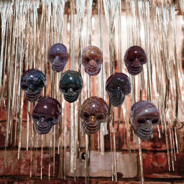 Agate skull pendants hanging on chains.