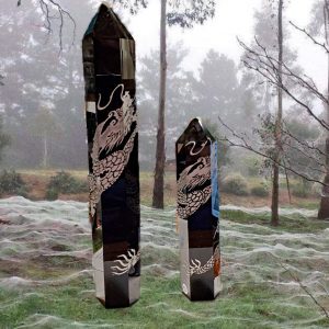 Two crystal dragon obelisks on grass.