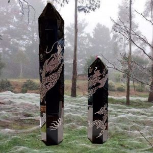 Two black crystal dragon wands on grass.