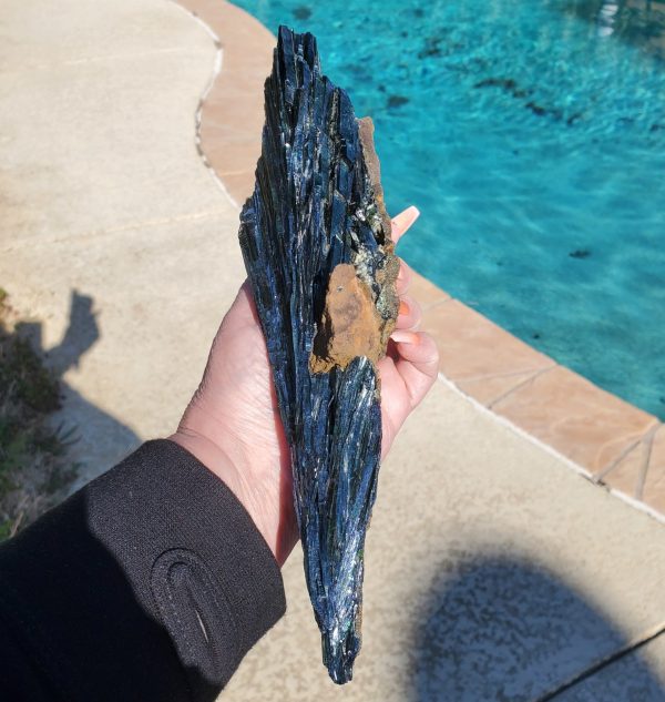Hand holding a blue and green crystal.