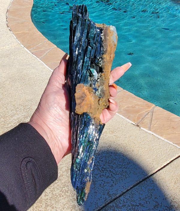 Hand holding a large blue crystal.