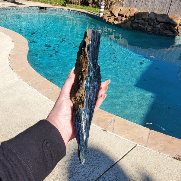 Hand holding a black tourmaline crystal.