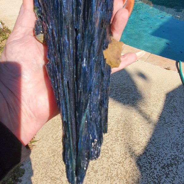 Hand holding a blue and green mineral.