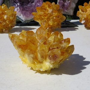 Yellow calcite crystal cluster on table.