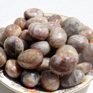 A bowl of sunstone tumbled stones.