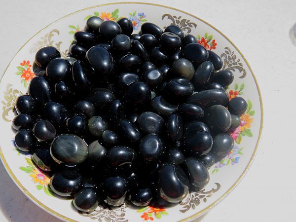 Black obsidian stones on a floral plate.