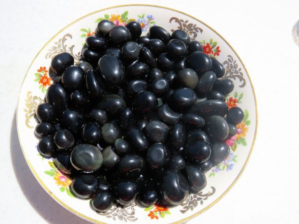 Black obsidian tumbled stones in a bowl.