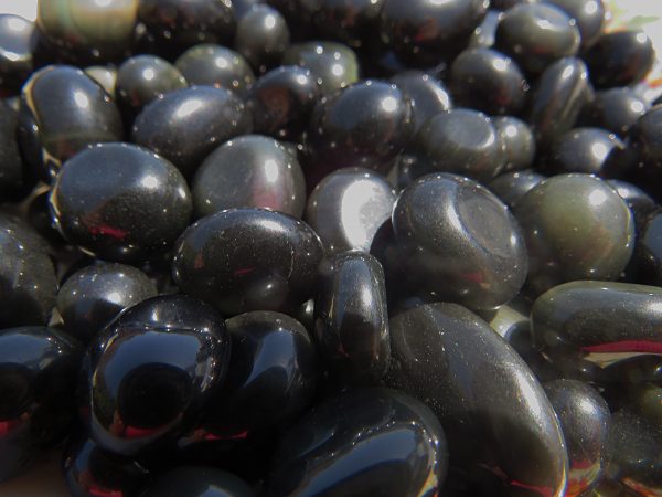 Shiny black stones on a surface.