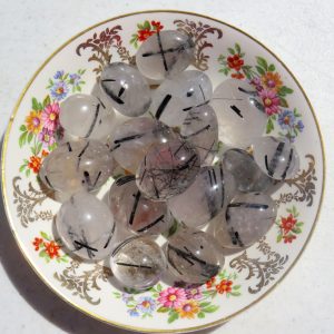 Black tourmaline quartz stones on a plate.