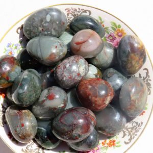 Polished moss agate stones on a plate.