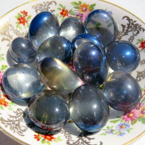 Shiny blue stones on a floral plate.