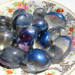 Shiny blue stones on a floral plate.