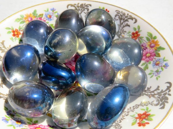 Shiny blue and white glass stones on a plate.