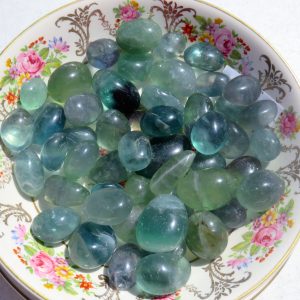 Green stones on a floral plate.