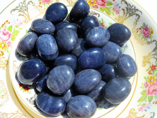 Blue tumbled stones on floral plate.