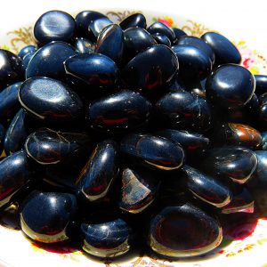 Shiny black and blue gemstone pebbles.