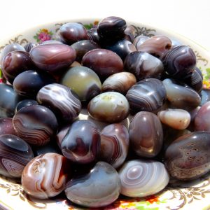 Polished banded agate stones in a bowl.