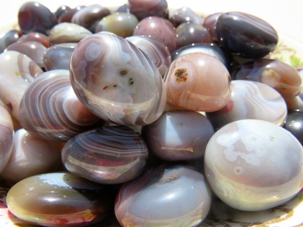 Smooth, banded agate stones in a bowl.