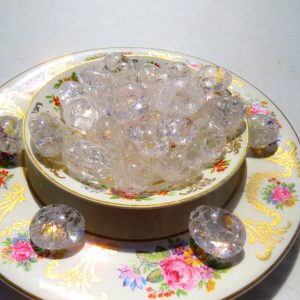 Clear glass beads in a floral bowl.