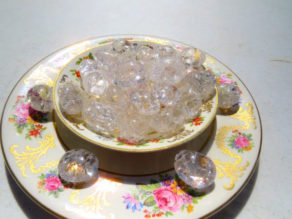 Clear glass beads in a floral bowl.