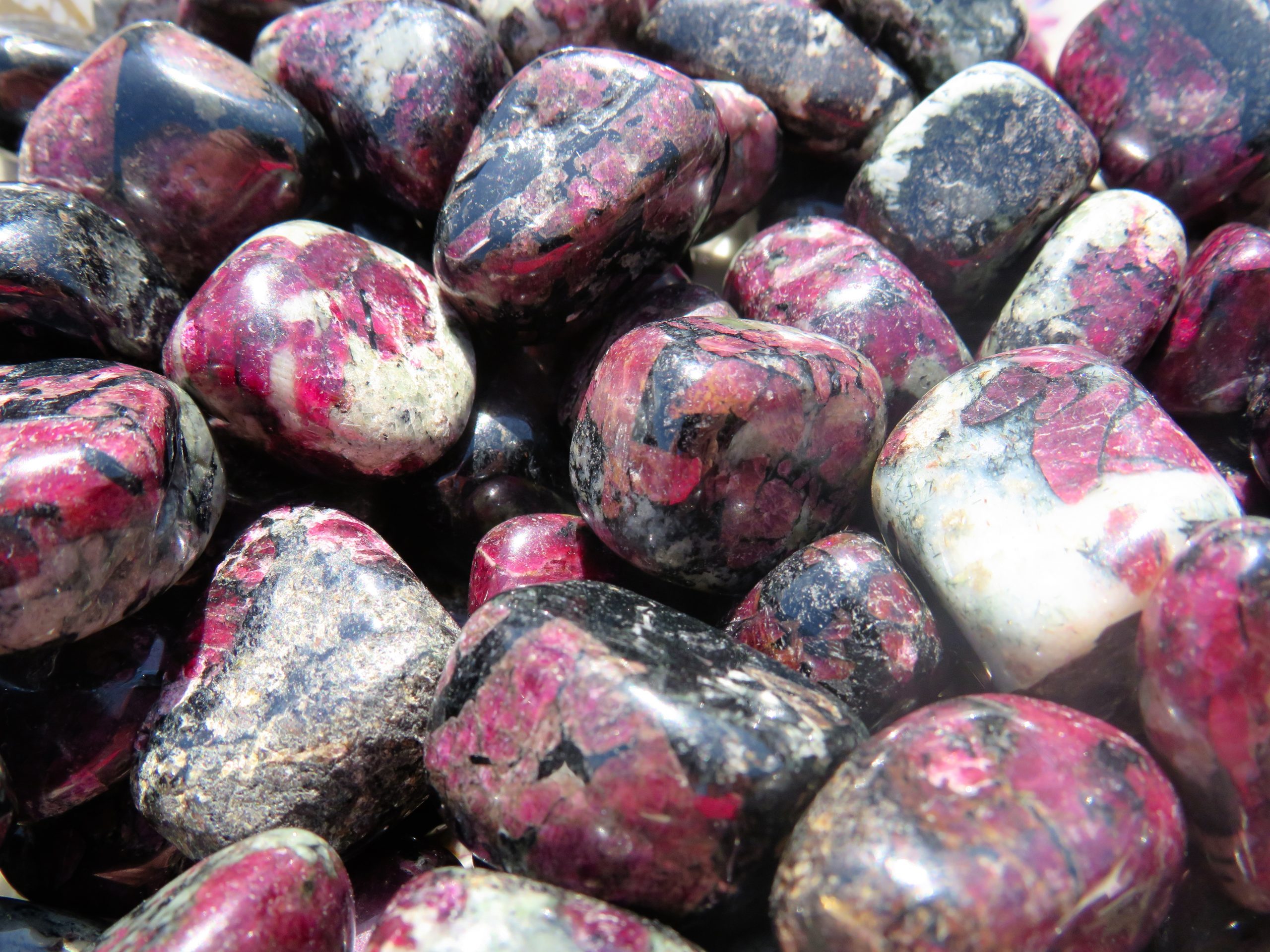 A pile of pink and black piedras preciosas.