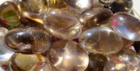 Close-up of a pile of smooth, smoky quartz gemstones.