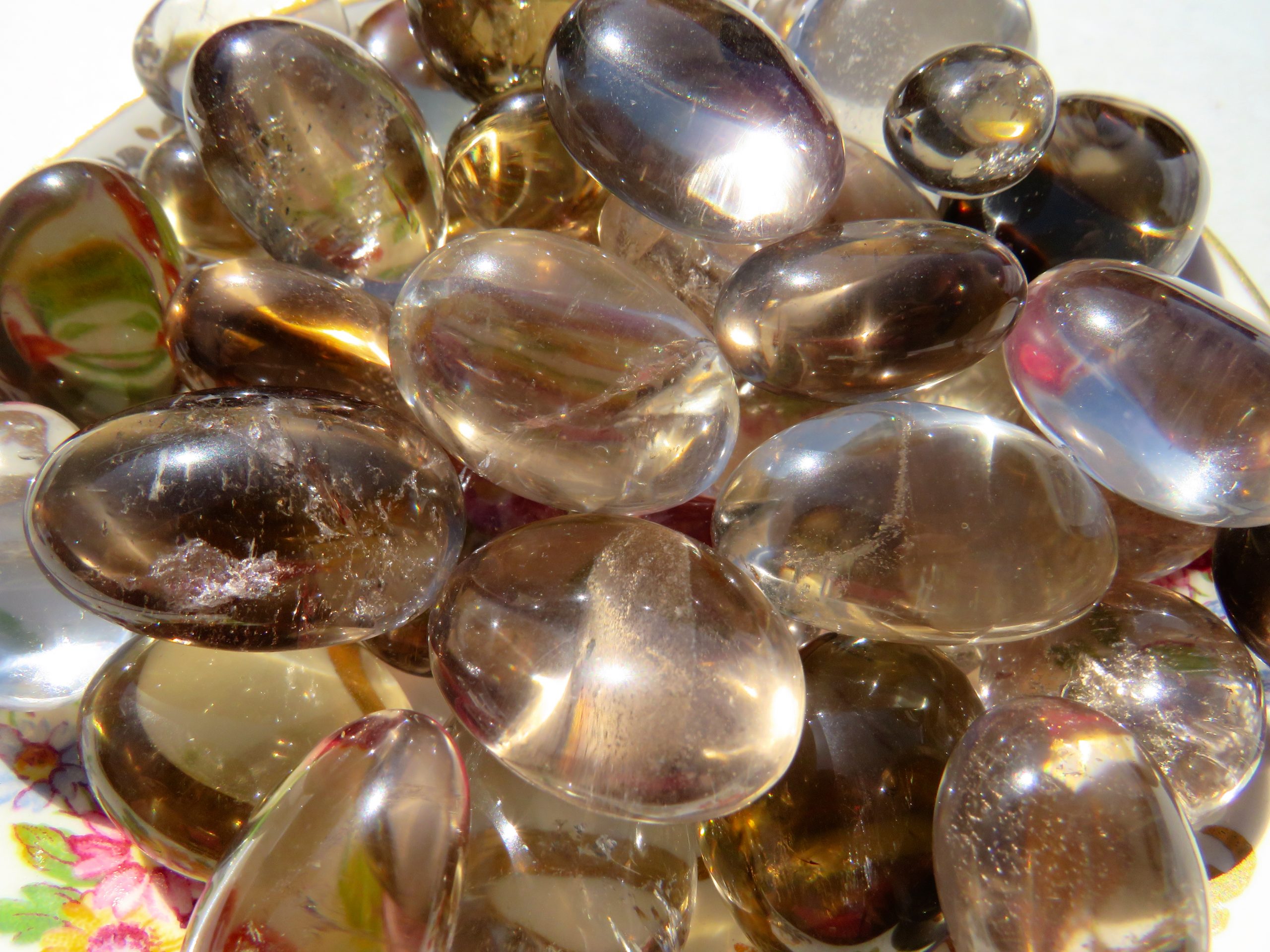 Close-up of a pile of smooth, smoky quartz gemstones.