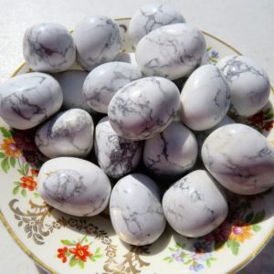 White howlite tumbled stones on plate.