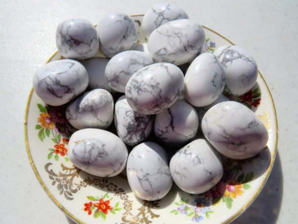 White howlite tumbled stones on plate.