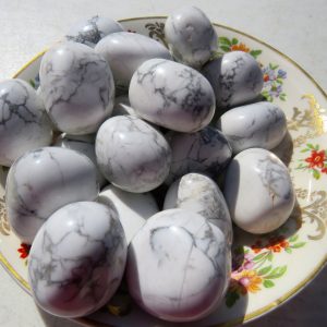 White howlite tumbled stones on a plate.