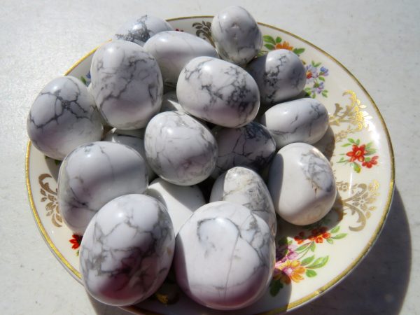 White howlite tumbled stones on a plate.