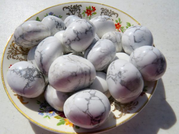 White howlite tumbled stones on a plate.