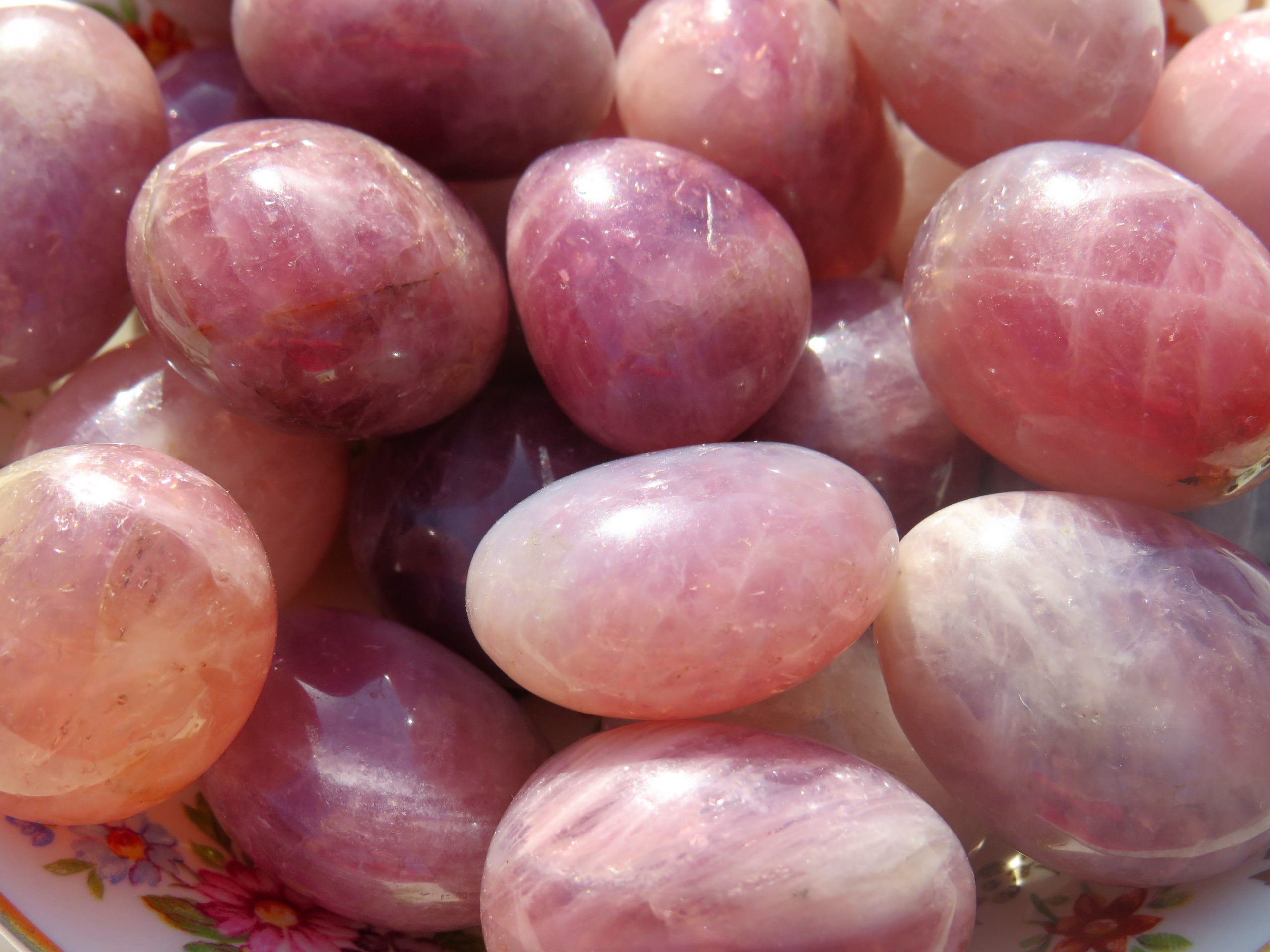 A bowl of Lavender Rose Quartz Tumbles in a floral pattern.