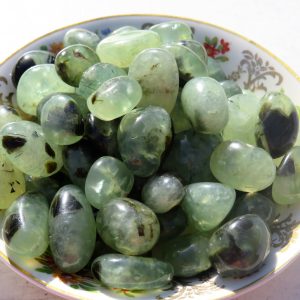 Green and black stones in a bowl.