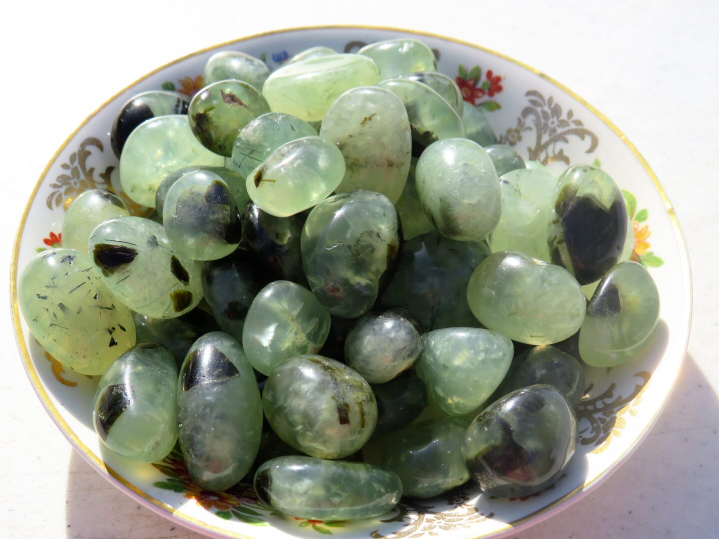 Green and black stones in a bowl.