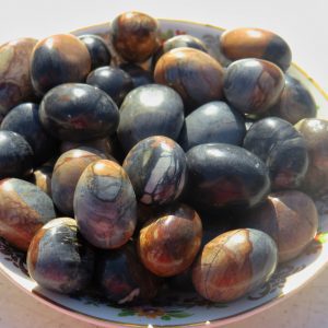 Polished black and brown stones in bowl.