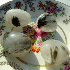 Four clear quartz stones on a plate.