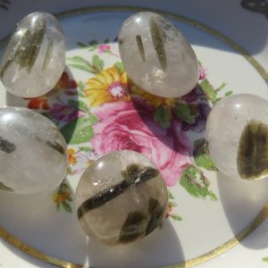 Five green and white tumbled stones.