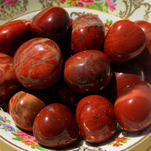 Red jasper stones in a floral dish.