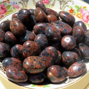 Red and black tumbled stones in a bowl.