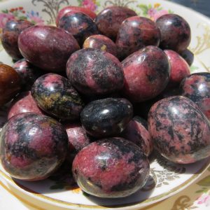 Polished pink and black gemstone eggs.