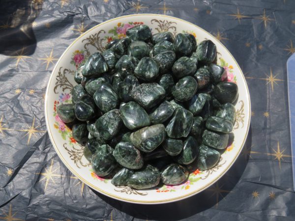 Green tumbled stones in a decorative bowl.
