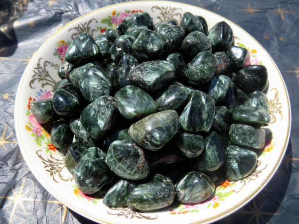 Green gemstone tumbled stones in a bowl.