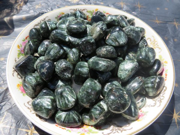 Green and black polished stones in a bowl.