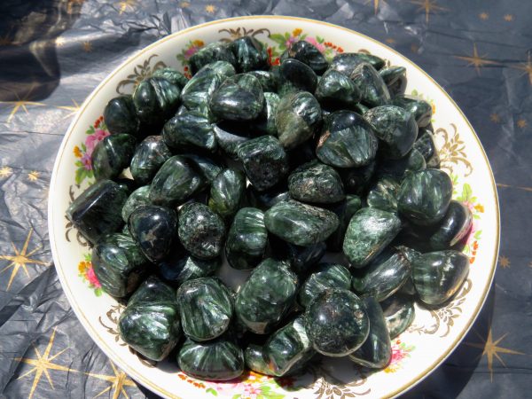 Green aventurine tumbled stones in a bowl.