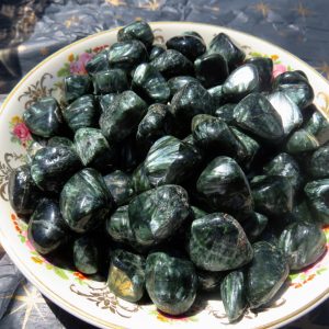 Green tumbled stones in a white bowl.