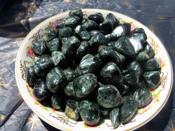 Green tumbled stones in a white bowl.