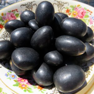 Black shiny stones in a floral bowl.