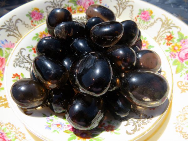 Black obsidian stones on a floral plate.