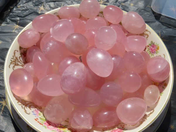 Pink rose quartz tumbled stones in bowl.